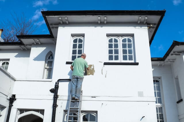 trabajador pintando la fachada de una casa