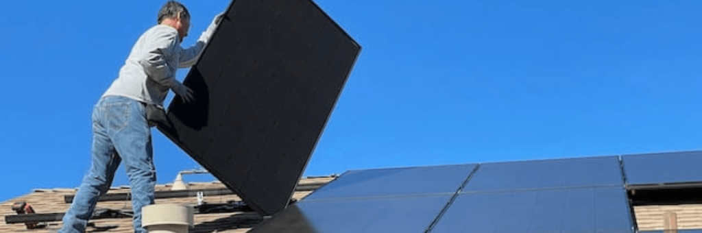hombre instalando placa solar sin seguridad