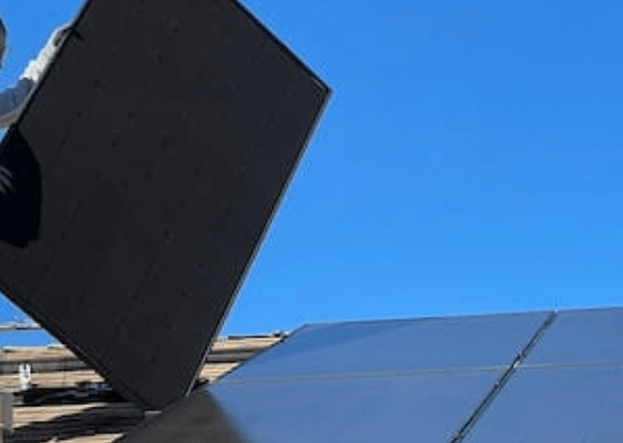 hombre instalando placa solar sin seguridad