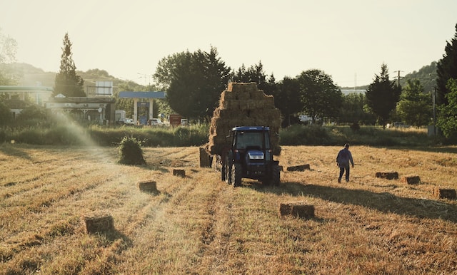 trabajador al lado de un tractor con altas temperaturas